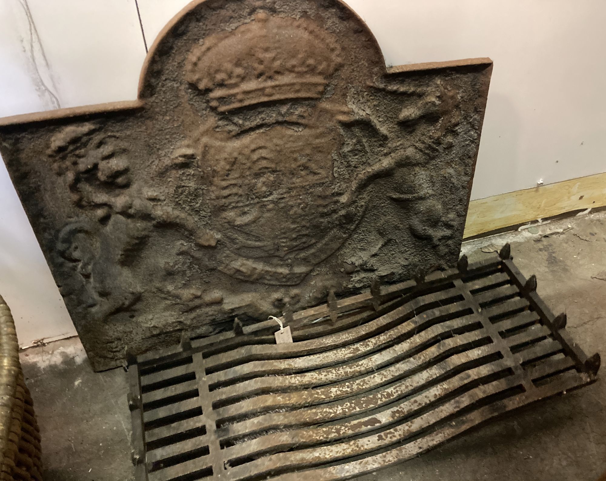 A 17th century style cast iron fire back, width 87cm, height 74cm and an iron grate (2)
